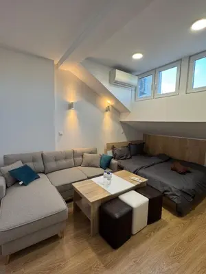 a living room with a couch and a table at Cozy High-Street Loft in Sofia's Best Central Location in Sofia