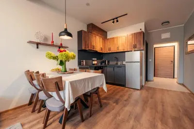 a kitchen and dining room with a table and chairs at Rila Family Haven in Samokov