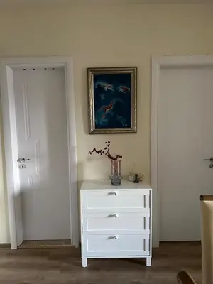 a white dresser with a vase on top of it at At Marti in Bansko