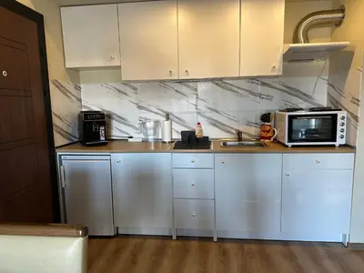 a kitchen with white cabinets and a microwave at At Marti in Bansko