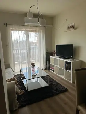 a living room with a glass coffee table and a television at At Marti in Bansko