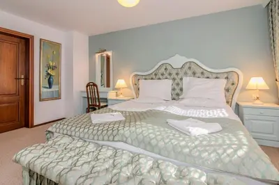 a bedroom with a large bed with two towels on it at Къща за гости Карлък in Smolyan