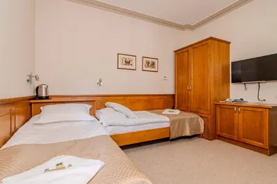 a bedroom with two beds and a flat screen tv at Къща за гости Карлък in Smolyan