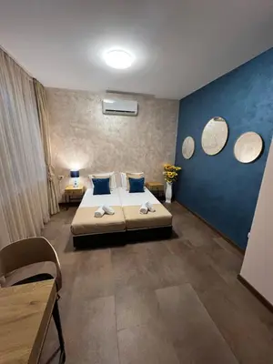 a bedroom with a bed with blue walls and mirrors at BoxRoom1 in Kyustendil
