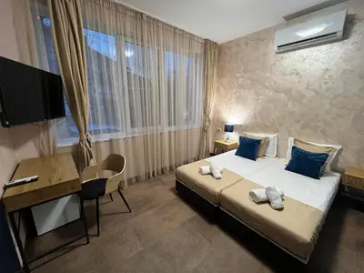 a bedroom with a bed and a desk and a television at BoxRoom1 in Kyustendil
