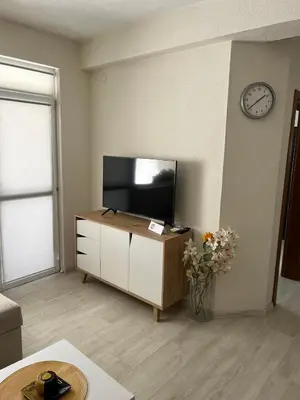 a living room with a flat screen tv on a cabinet at Positive Apartment in Petrich