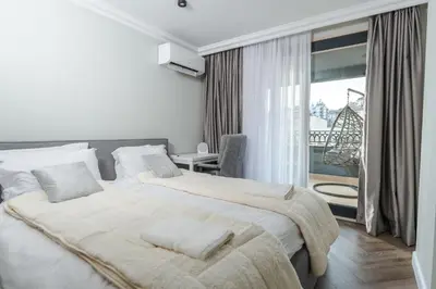 a bedroom with two beds and a large window at Simaya, your home in the heart of Sandanski in Sandanski