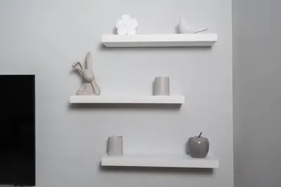 two white shelves on a white wall with items on them at Simaya, your home in the heart of Sandanski in Sandanski