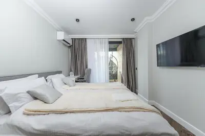 two beds in a white room with a tv at Simaya, your home in the heart of Sandanski in Sandanski