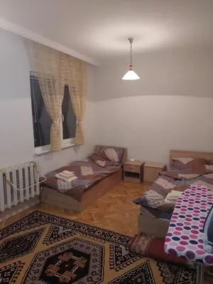 a living room with two beds and a rug at апартамент У дома in Plovdiv