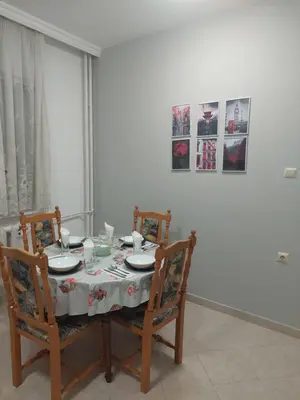 a dining room table with two chairs and a tablecloth on it at апартамент У дома in Plovdiv