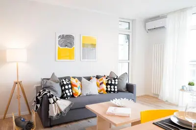 a living room with a blue couch with colorful pillows at Scandinavian Airy APT in Business Area & Airport in Sofia