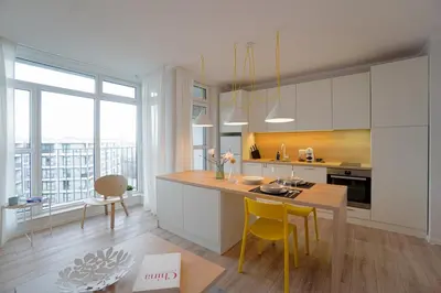 a kitchen with white cabinets and a table with yellow chairs at Scandinavian Airy APT in Business Area & Airport in Sofia