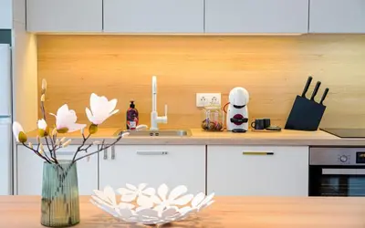 a kitchen counter with a vase of flowers on a table at Scandinavian Airy APT in Business Area & Airport in Sofia