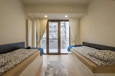 two beds in a room with a large window at Stylish TOP center Flat 100m to Vitosha blvd in Sofia