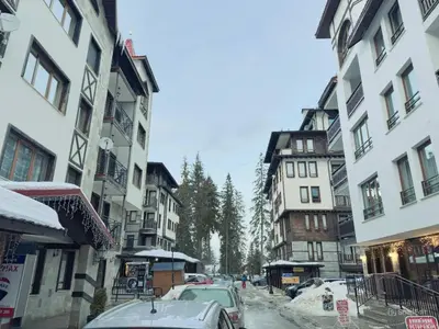 a snowy street in a city with buildings at Dream View Family Retreat in Pamporovo