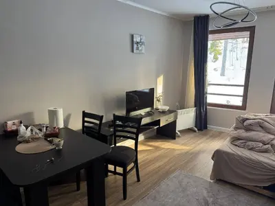 a living room with a table and a desk with chairs at Dream View Family Retreat in Pamporovo