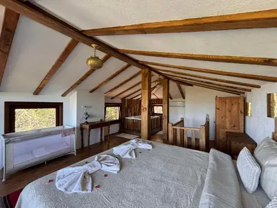 a bedroom with a large bed in a room at Вили Панорама Лещен in Leshten