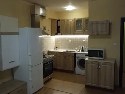 a kitchen with a white refrigerator and a microwave at Апартамент за гости 