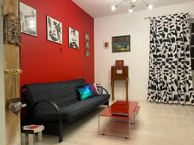 a living room with a black couch and a red wall at Art city studio in Sofia center in Sofia