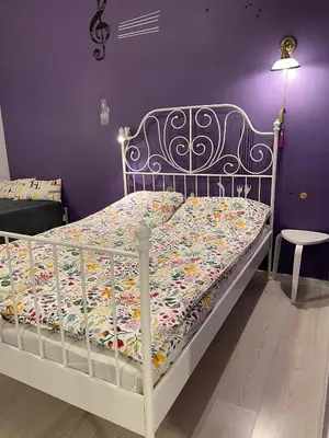 a bed in a room with a purple wall at Art city studio in Sofia center in Sofia