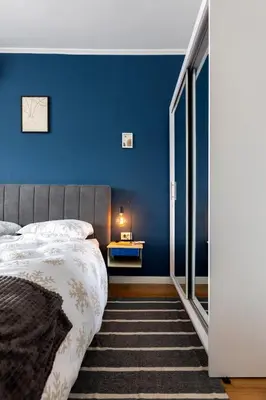 a bedroom with a bed and a blue wall at Modern 1 Bedroom by the Gondola in Bansko