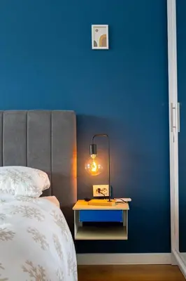 a blue bedroom with a bed and a table with a lamp at Modern 1 Bedroom by the Gondola in Bansko