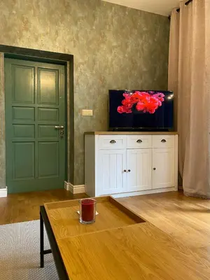 a living room with a tv on top of a cabinet at Cozy townhouse in the heart of Sofia in Sofia