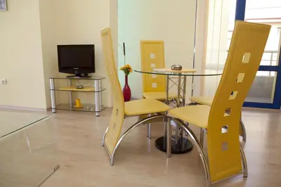 a room with a table and chairs and a television at Spa Villa Crystal in Hisarya
