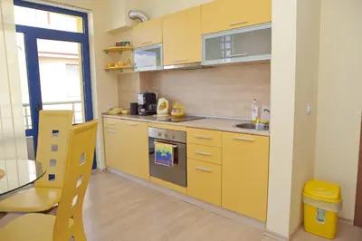 a yellow kitchen with a sink and a stove at Spa Villa Crystal in Hisarya