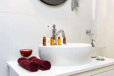 a bathroom sink with red towels on a counter at Kapana Art Sky Studios Parking Included in Plovdiv