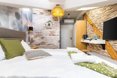 a bedroom with a white bed and a brick wall at Kapana Art Sky Studios Parking Included in Plovdiv