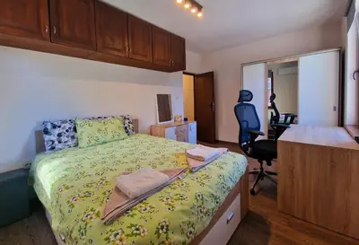 a bedroom with a bed and a desk and a chair at Next to Kapana - Art Apartment in Plovdiv