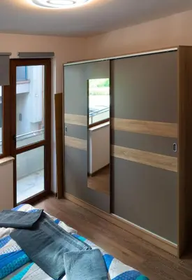 a bedroom with a sliding glass door with a mirror at Next to Kapana - Art Apartment in Plovdiv