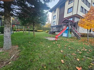 a playground in a yard next to a house at AZAX Apartments in Terra Complex in Bansko
