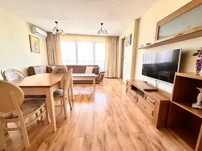 a living room with a dining table and a television at Cite Jardin in Sofia
