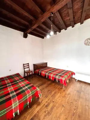 a room with two beds and a chair in it at Nadejda Guest House in Tyzha in Tŭzha