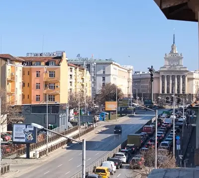 a busy city street with parked cars and buildings at Victoria Elegance Apartment in Sofia