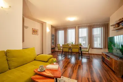 a living room with a yellow couch and a table at GREEN STAR Grand Resort Pamporovo in Pamporovo