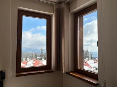 two windows in a room with a view of snow at GREEN STAR Grand Resort Pamporovo in Pamporovo
