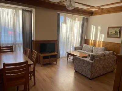 a living room with a couch and a table at Pirin Golf Resort & SPA Two-Bedroom Apartment in Razlog