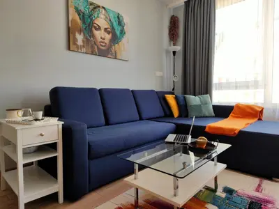 a blue couch in a living room with a table at Prima apartment in Sofia