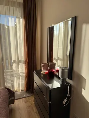 a bedroom with a dresser with a mirror and a window at Borovets Gardens MVS Apart D42 in Borovets
