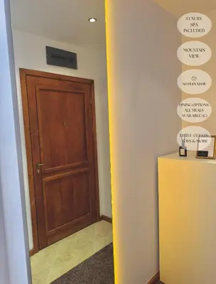 a hallway with a wooden door and a wall with signs at Luxfjäll Ivan Rilski - Full Spa & Pool in Bansko