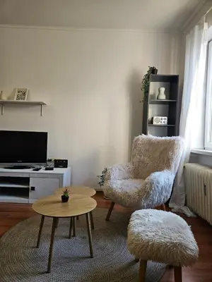 a living room with a chair and a table at City Center Park Apartment in Sofia