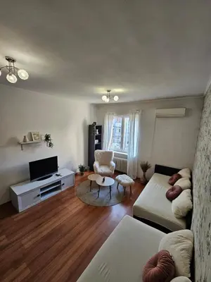 a living room with a couch and a tv at City Center Park Apartment in Sofia