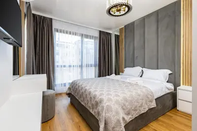 a bedroom with a bed and a large window at Two-Bedroom Apartments with Free Private Parking and 6min to Center in Plovdiv
