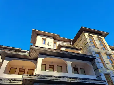 a building with white windows and a blue sky at Георгиев Луксури Апарт in Pamporovo