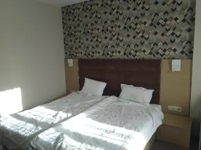 a bed with white sheets and pillows in a bedroom at Георгиев Луксури Апарт in Pamporovo
