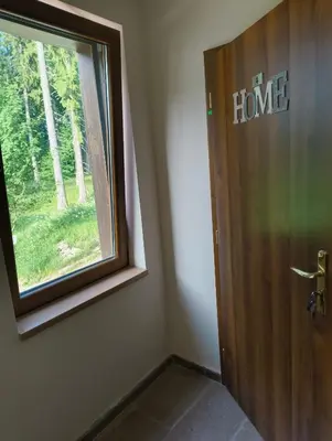a door with the word home written on it next to a window at Evrika home 4 in Pamporovo